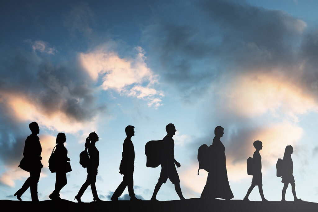 Silhouette of refugees walking in a row