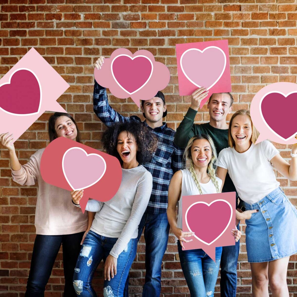 diverse group holding cards with hearts on them