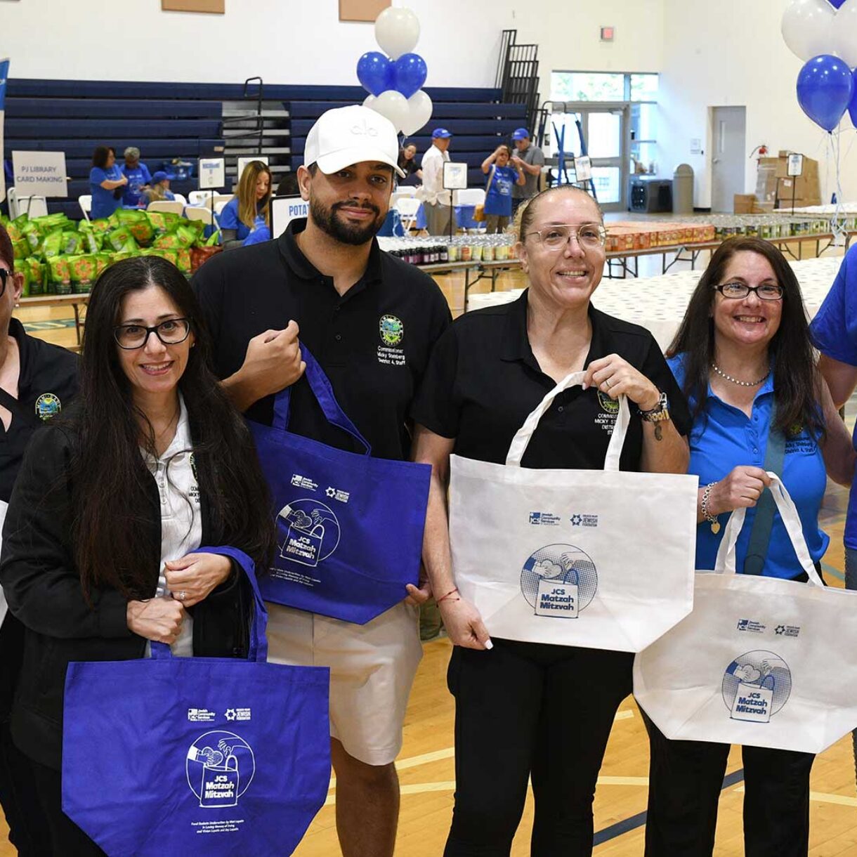 Volunteers show bags to be filled with necessities for seniors and Holocaust Survivors at Matzah Mitzvah 2026