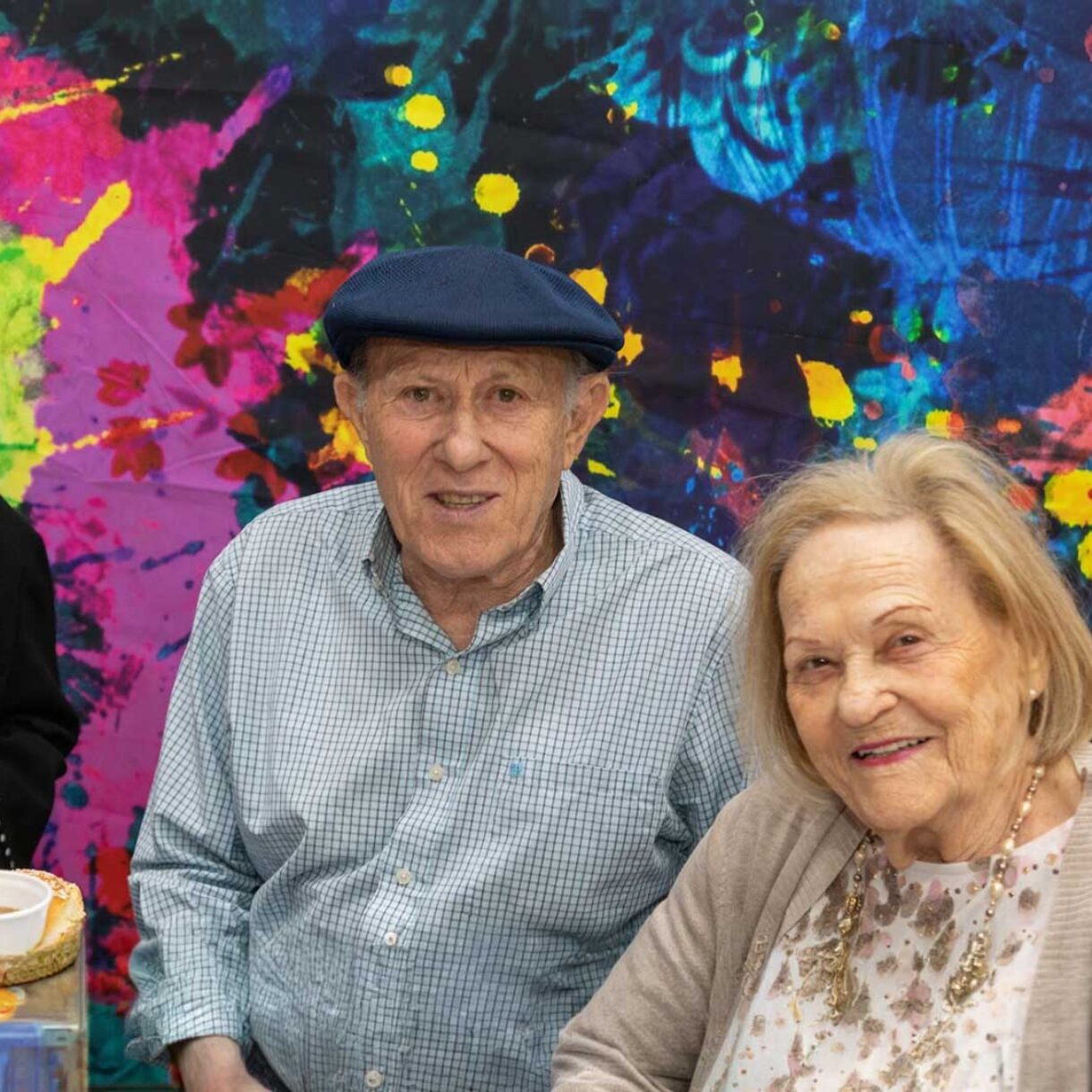 3 seniors sit together to eat at a table